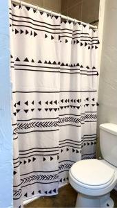 a bathroom with a black and white shower curtain at The House Hotels - Lark 1 in Lakewood