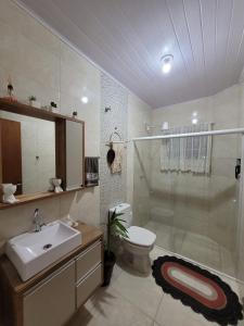a bathroom with a toilet and a sink and a shower at Recanto Dona Fatima in Itapoa