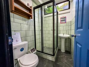 a bathroom with a shower and a toilet and a sink at Casitas Coloradas Puerto Viejo in Puerto Viejo