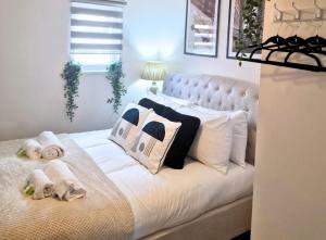 - un lit blanc avec des serviettes et des oreillers dans l'établissement Manchester Apartments by BEVOLVE - City Centre, à Manchester