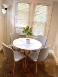 萊克伍德的住宿－The House Hotels - Lark 2，一张带四把椅子的白色桌子和一株植物