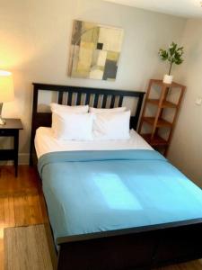 Schlafzimmer mit einem Bett mit blauer Bettwäsche und weißen Kissen in der Unterkunft The House Hotels - Lark 2 in Lakewood