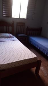 a bedroom with two beds and two chairs and a window at Hostel Sancris 2 in São José dos Campos