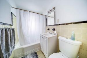 a bathroom with a toilet and a sink and a tub at Cozy Euclid Apartment Near Downtown! in Euclid