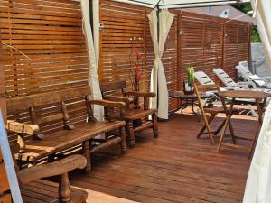 una terraza de madera con bancos, mesas y sillas en habitaciones con piscina en tinguiririca san fernando, en San Fernando