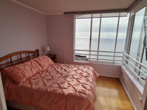 a bedroom with a bed and a large window at Reñaca-Cochoa Vista Mar-3D -funicular directo playa in Viña del Mar