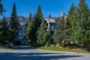 ein großes Haus mit Bäumen vor einer Auffahrt in der Unterkunft Blueberry Hill Premium Area in Whistler