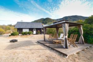 a group of chairs sitting under a gazebo at しまなみ宿sagi in Mukaitanoura