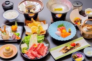 un tavolo con diversi piatti di cibo sopra di glampark Kaiyokaku Aichi a Gamagōri