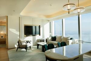 a living room with a couch and a table and chairs at Shangri-La Nanshan, Shenzhen in Shenzhen