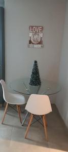 une table en verre avec un arbre de Noël et deux chaises dans l'établissement Circa unit 91, à Pretoria