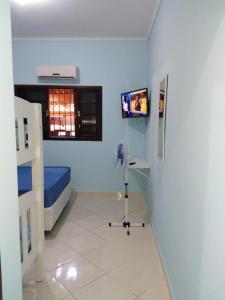 um quarto de hospital com uma cama e uma televisão em Casa Gomes Itagua em Ubatuba