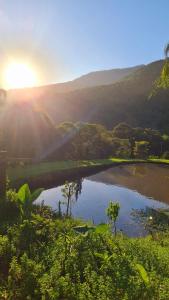 a reflection of the sun in a pond in a field at Cabana valle Pietra Hospedagem sofisticada em Nova Petrópolis in Nova Petrópolis