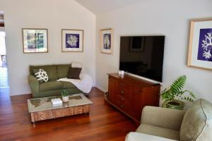a living room with a couch and a tv at Coastal Contentment in the Cove in North Arm Cove