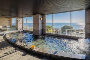 a large indoor swimming pool with a view of the ocean at glampark Kaiyokaku Aichi in Gamagori