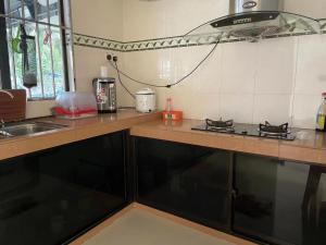 a kitchen with a sink and a stove top oven at Sibu Homestay Happy Family in Sibu