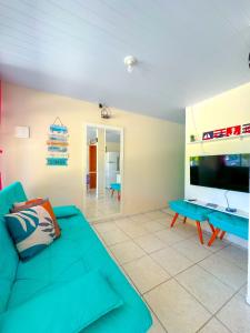 ein Wohnzimmer mit einem blauen Sofa und einem Tisch in der Unterkunft Casa de Anita Pinheira 30m da praia in Palhoça