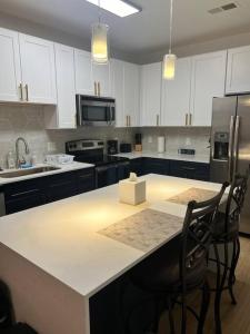 a kitchen with white cabinets and a kitchen island with chairs at Uptown Luxury Suite Near It All in Charlotte