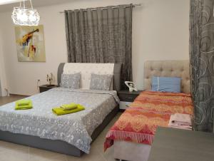 1 dormitorio con 2 camas con asas amarillas en Dhoma romantike , qetesi absolute!, en Korçë
