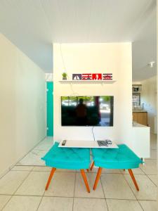 ein Wohnzimmer mit einem Tisch und einem TV in der Unterkunft Casa de Anita Pinheira 30m da praia in Palhoça