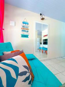 ein Wohnzimmer mit einem blauen Sofa und einem Spiegel in der Unterkunft Casa de Anita Pinheira 30m da praia in Palhoça