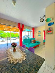 ein Wohnzimmer mit einem Tisch und einem blauen Sofa in der Unterkunft Casa de Anita Pinheira 30m da praia in Palhoça