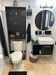 a bathroom with a toilet and a sink and a mirror at A Luxury Master Bedroom in a Condo in Los Angeles