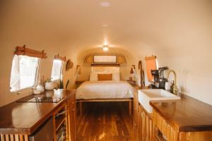 uma cozinha com uma cama e um lavatório num quarto em La Caravana em Sámara