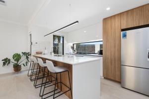 a kitchen with a white island with bar stools at Luxury Urban Retreat in Perth