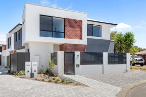 a white house with black windows and a driveway at Luxury Urban Retreat in Perth
