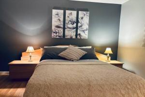 een slaapkamer met een bed met drie schilderijen aan de muur bij Ahava, Centropolis Laval in Laval
