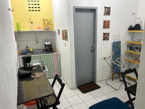 eine Küche mit einem Tisch und einer Tür in einem Zimmer in der Unterkunft Betesda 2197E KITNET in São Luís