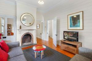 a living room with a tv and a fireplace at Palm Cottage in Port Fairy