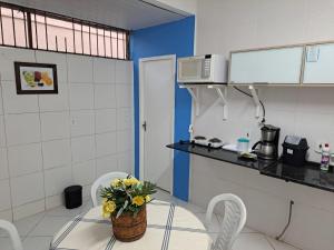 una cocina con una mesa con una cesta de flores. en Buzios Suites - com Garagem, en Búzios