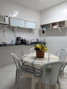 una cocina con una mesa con una cesta de flores. en Buzios Suites - com Garagem, en Búzios