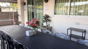a long table with chairs and flowers on it at Prime House Bangsaen in Ban Thai Don (1)