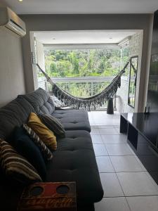 a living room with a couch and a hammock at Rio Centro Barra da Tijuca in Rio de Janeiro