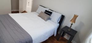 彼得斯堡Cozy newly renovated house的卧室配有白色的床和带灯的床头柜