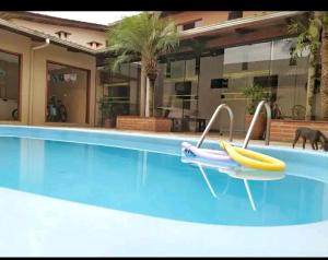 莫雷蒂斯Pousada Casa Morretes的游泳池中的冲浪板和冲浪板