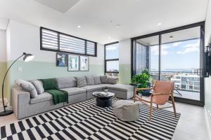 a living room with a couch and a chair at Kula Wollongong in Wollongong
