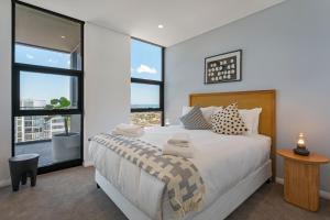 a bedroom with a bed and a large window at KULA Wollongong in Wollongong