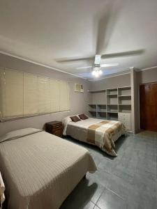 een slaapkamer met 2 bedden en een plafondventilator bij Quinta con piscina BitcoinsHouse Los Azahares Santa Ana in Laguna Brava