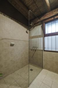a bathroom with a shower with a glass door at Aguacanto Cabañas in Tilcara
