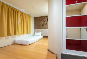 a room with a white bed and a window at Swing & Pillows - PJ SS2 in Petaling Jaya