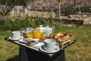 una mesa de picnic con una cesta de pan y bebidas en Aguacanto Cabañas en Tilcara