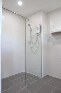 a shower with a glass door in a bathroom at โรงแรมบลอสซั่ม เพชรบูรณ์ Blossom Hotel in Phetchabun