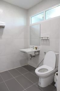 a white bathroom with a toilet and a sink at โรงแรมบลอสซั่ม เพชรบูรณ์ Blossom Hotel in Phetchabun