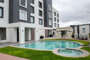 a swimming pool in front of a building at HOTEL MERLOT INN in Ezequiel Montes