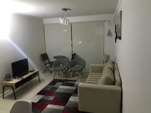 a living room with a couch and a table and chairs at Condominio Parquemar in El Tabo