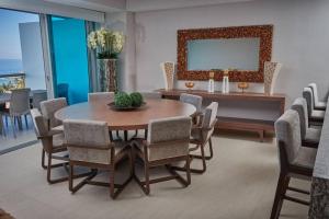 a dining room with a table and chairs and a mirror at Ixtapa sensacional in Zihuatanejo